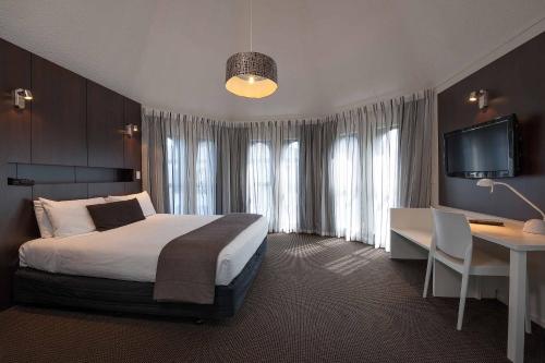 基督城公园塔楼酒店的酒店客房配有一张床、一张书桌和一台电视。