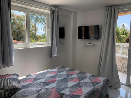 嘎林海斯港Makaiba Residence Flat dr Artur Licio的一间卧室设有一张床和两个窗户。