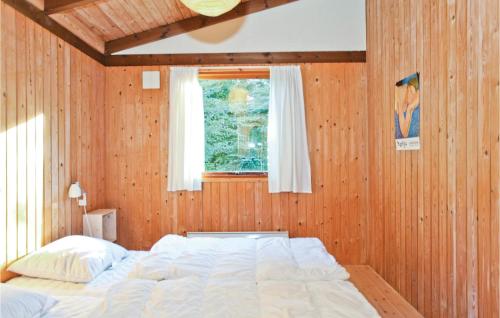 ReersøStunning Home In Store Fuglede With Wifi的卧室配有一张木墙内的大床