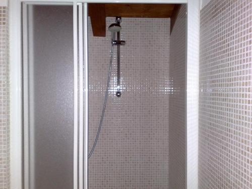 德尔维奥斯蒂夫别墅旅馆的浴室设有白色瓷砖墙壁和淋浴。