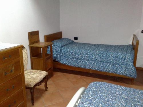 德尔维奥斯蒂夫别墅旅馆的一间卧室配有两张床、椅子和梳妆台