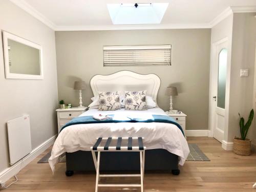 开普敦Garden Cottage - Leafy Constantia Guest House的一间卧室配有一张带白色床头板的床