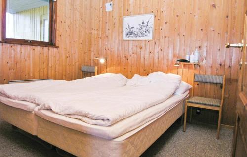哈夫維格Awesome Home In Hvide Sande With Sauna的卧室配有一张木墙内的大床