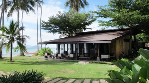 麦岛科马克塞瓦纳沙滩度假酒店的一座小房子,上面有草坪和棕榈树