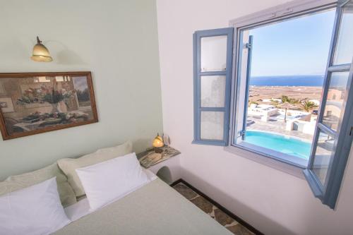 伊亚安尼摩沙别墅酒店的一间卧室设有一张床和一个美景窗户。