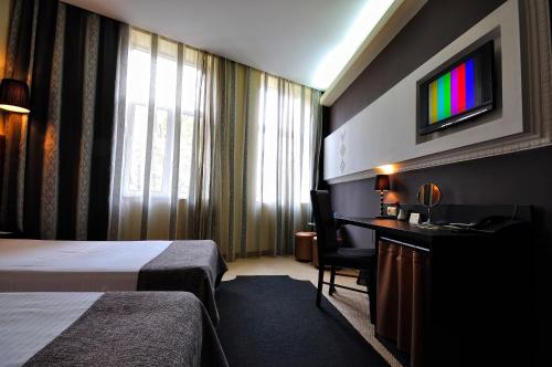 鲁塞城市艺术精品酒店的酒店客房设有一张床、一张书桌和一台电视机。