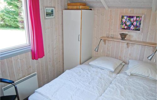 斯泰厄Nice Home In Stege With 3 Bedrooms, Sauna And Wifi的一间小卧室,配有白色的床和冰箱