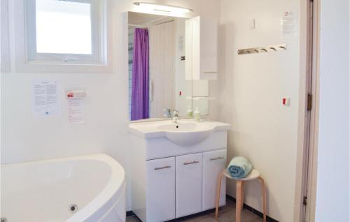 Udsholt SandCozy Home In Grsted With Kitchen的白色的浴室设有浴缸、水槽和浴缸。