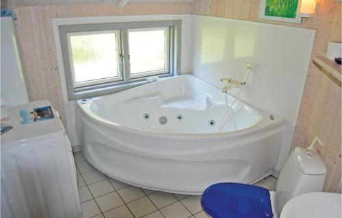 斯泰厄Nice Home In Stege With 3 Bedrooms, Sauna And Wifi的带窗户的浴室内的白色大浴缸