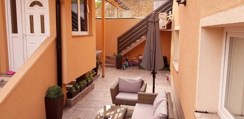 萨格勒布Apartments Lisinski - Private parking的户外庭院配有遮阳伞、沙发和椅子。
