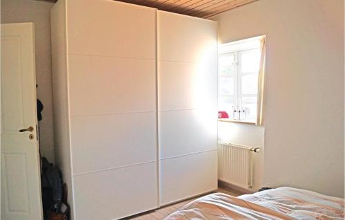 米泽尔法特Stunning Apartment In Middelfart With Kitchen的卧室配有一张位于床边的白色大橱柜