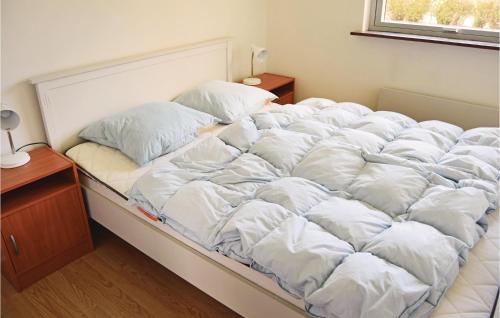 Skattebølle2 Bedroom Awesome Home In Tranekr的一张配有白色床单和枕头的大床