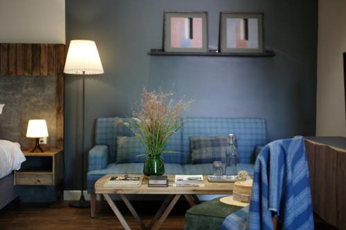 岘港Kaia Residence Danang Quiet Garden的客厅配有蓝色的沙发和桌子