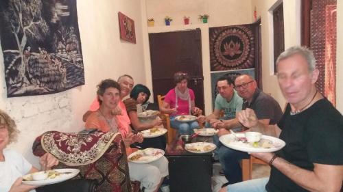 瓦拉纳西Mother Hostel的一群人坐在一个有食物盘的房间