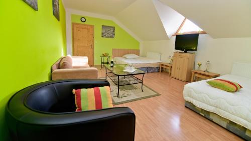 Dolní MoraviceWellness Penzion Eva的一间卧室设有绿色的墙壁、一张沙发和椅子