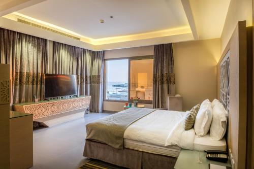 吉达Ewaa Express Hotel - Al Hamra的一间卧室设有一张大床和一个大窗户