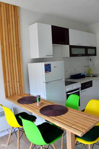 萨拉热窝Stan na dan, Sarajevo的厨房配有木桌和绿色椅子