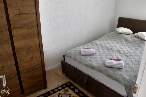 萨拉热窝Stan na dan, Sarajevo的一间卧室配有一张床,上面有两条毛巾