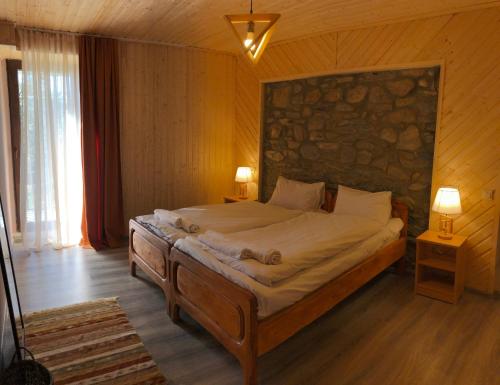 梅斯蒂亚Guest House Keti Margiani Mestia的一间卧室设有一张带石墙的大床