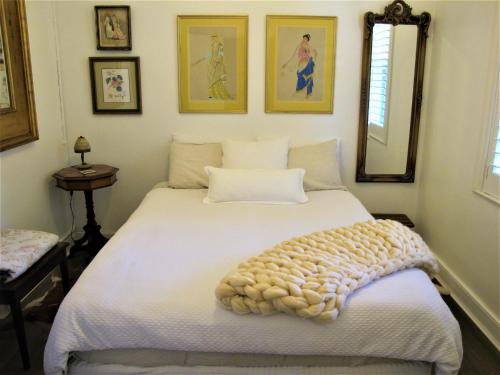 米塔贡艾普其度假屋的卧室配有一张白色的床,床上有毯子