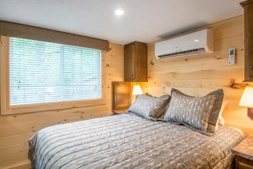 CroakerWilliamsburg Camping Resort 38 ft. Park Model 5的一间卧室设有一张床和一个窗口