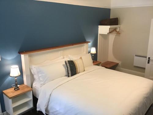 斯特拉恩Harrison House的卧室配有白色床和蓝色墙壁