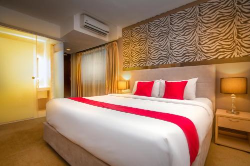 吉隆坡Royce Hotel @ KL Sentral的卧室配有带红色枕头的大型白色床