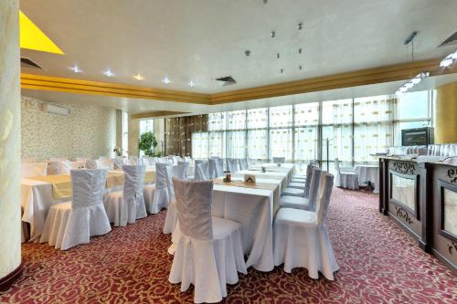 旧扎戈拉梅里安宫酒店的宴会厅配有白色的桌子和白色的椅子