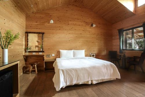 鱼池乡悠森境渡假村的一间卧室设有一张床和木墙