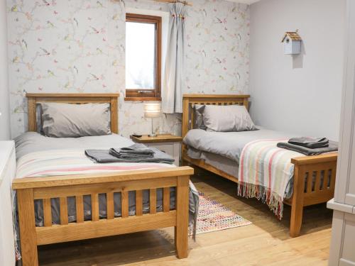 南特威奇Woodman's Lodge的一间卧室设有两张床和窗户。