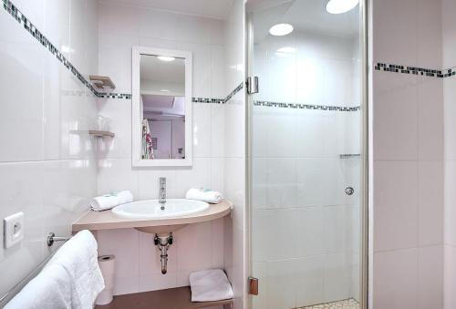 耶尔Hôtel Club la Font des Horts的白色的浴室设有水槽和淋浴。