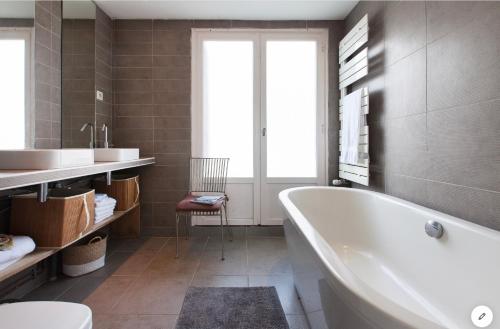 孔卡尔诺Aux 4 Sardines T2 56m2的带浴缸、盥洗盆和卫生间的浴室