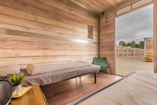 慕尼黑慕尼黑啤酒节维森营地旅馆的一间设有两张床和木墙的房间