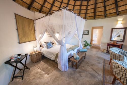 侯斯普瑞特Nyala Safari Lodge的一间卧室配有一张带蚊帐的床