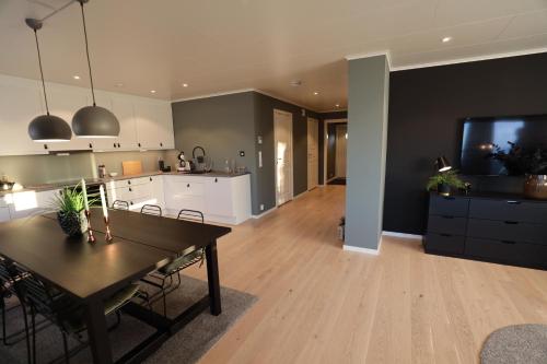 HamarvikModern apartment with seaview的厨房以及带桌子和电视的客厅。
