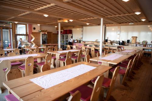 GanterschwilRestaurant und Kaeserei Berghof的一间空餐厅,配有木桌和椅子