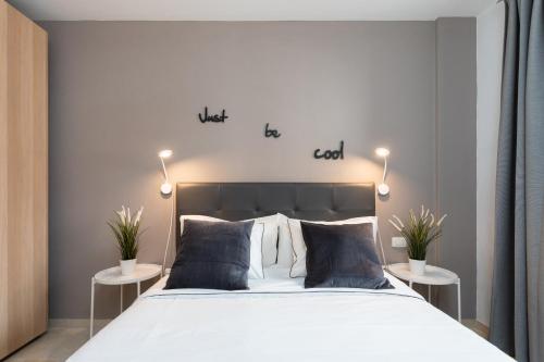 圭马尔港Home2Book Cozy Apartment Puertito, Wifi的一间卧室配有床和两张植物桌子