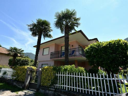 梅尔戈佐Belvilla by OYO Cherry House的棕榈树和白色围栏的房子