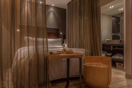 巴黎喜登酒店的卧室配有1张床、1张桌子和1把椅子