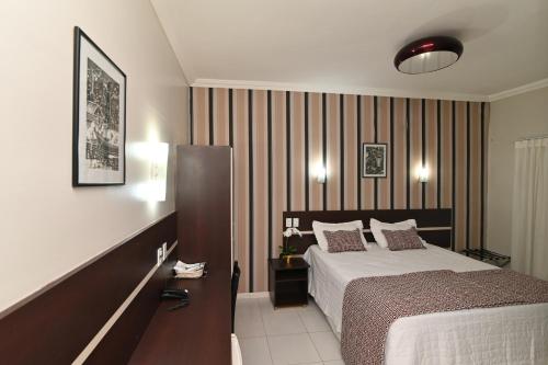 马拉巴圣本托酒店的酒店客房配有一张床和一张带西德丝床的书桌。