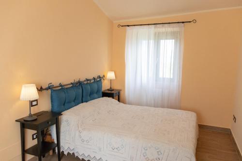 斯波莱托Alloggio turistico Montelirossi的一间卧室配有一张带蓝色床头板的床和窗户