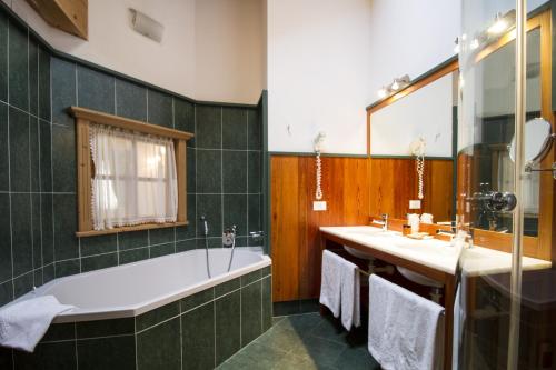 摩德纳迪-坎皮格里奥卡萨坎波酒店的浴室配有两个盥洗盆和浴缸。