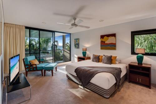 汉密尔顿岛Waves 3 Luxury 3 Bedroom Endless Ocean Views Central Location + Buggy的一间卧室配有一张床和一台平面电视