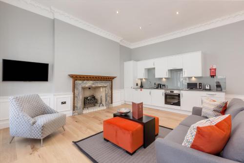 爱丁堡Destiny Scotland Hanover Apartments的带沙发、椅子和壁炉的客厅