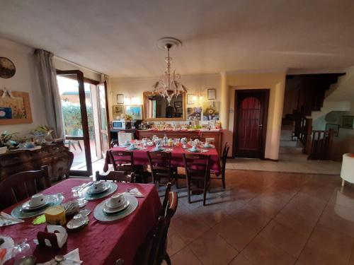 布伦巴泰B&B L'Isola di Casa的一间带红色桌椅的用餐室和一间厨房