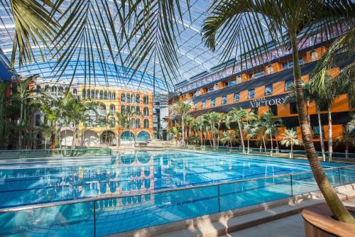 埃尔丁Hotel Victory Therme Erding的一座拥有玻璃天花板的酒店的大型游泳池