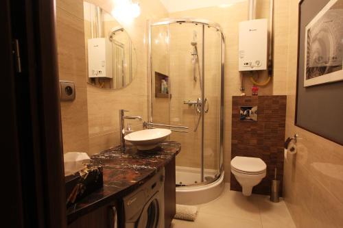 华沙克拉克夫郊区街“昼夜”公寓的带淋浴、盥洗盆和卫生间的浴室