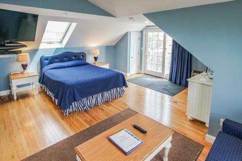 法尔茅斯Beachside Village Resort, a VRI resort的一间卧室配有一张蓝色的床和一张桌子