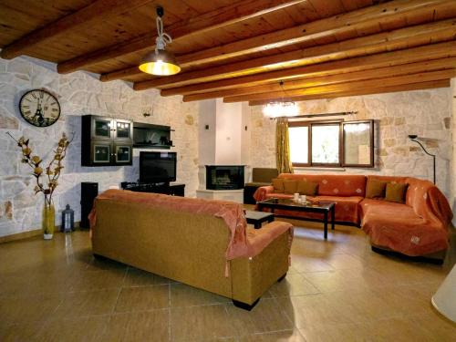 查加基恩Rouveli Villa with private garden and barbeque的带沙发和石墙的客厅