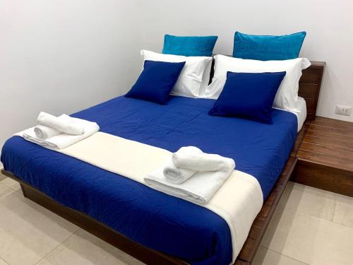 那不勒斯SECRET ROOM NAPLES historic center的蓝色和白色的床,配有蓝色枕头和毛巾